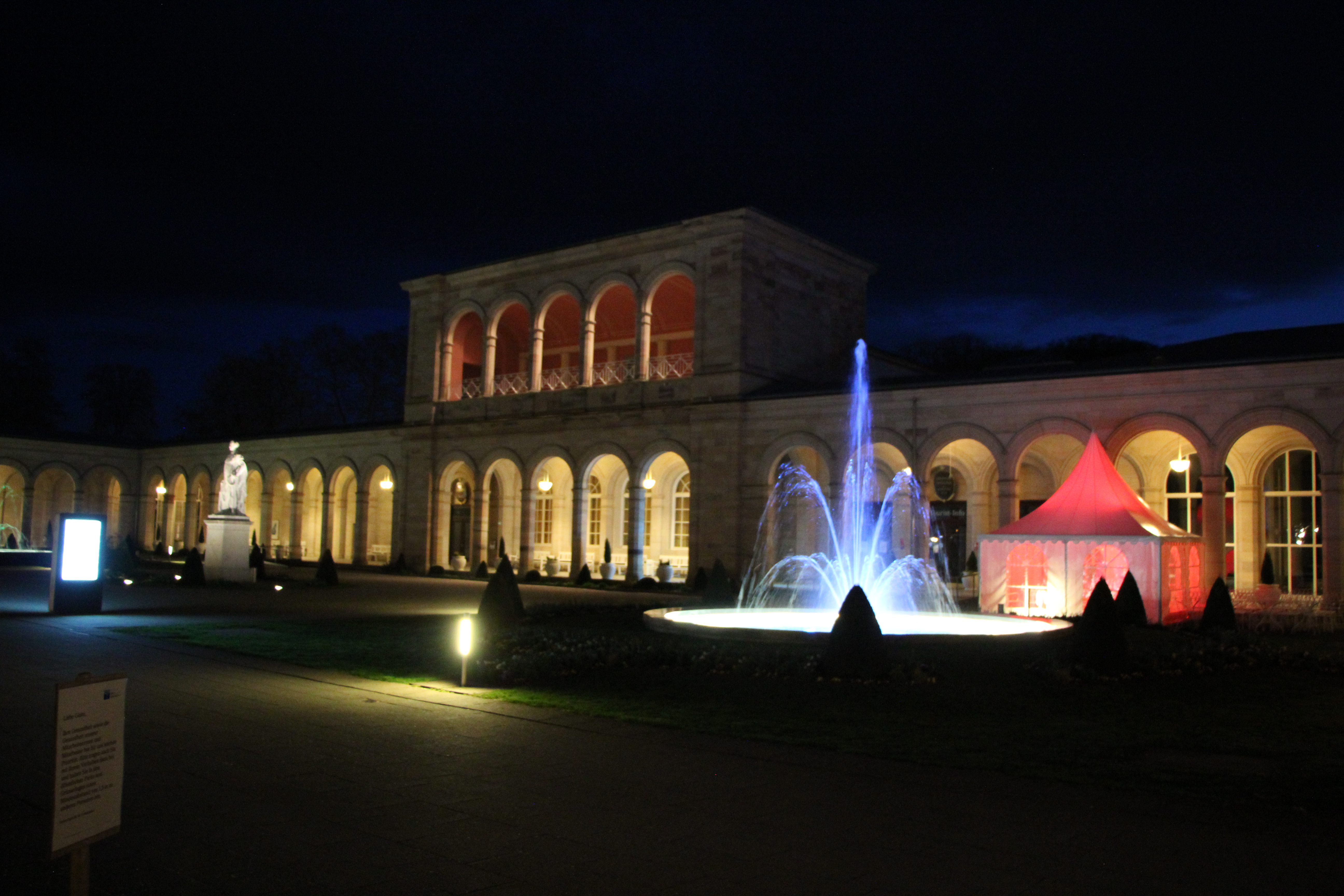 Beleuchtete Außenanlage bei Nacht mit Architektur- und Brunnenlicht