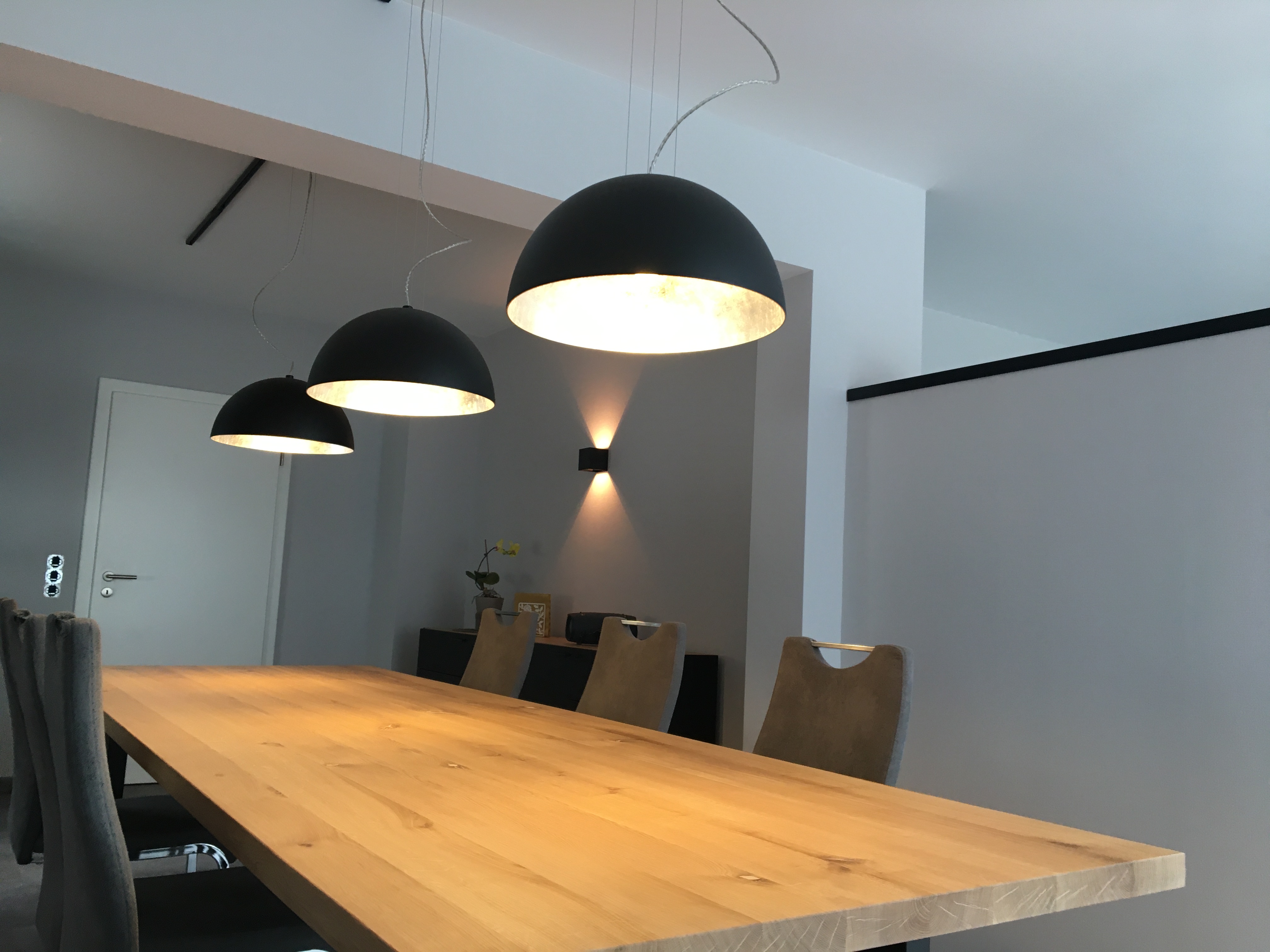 Esstisch mit abgestimmten Pendelleuchten und Wandlicht