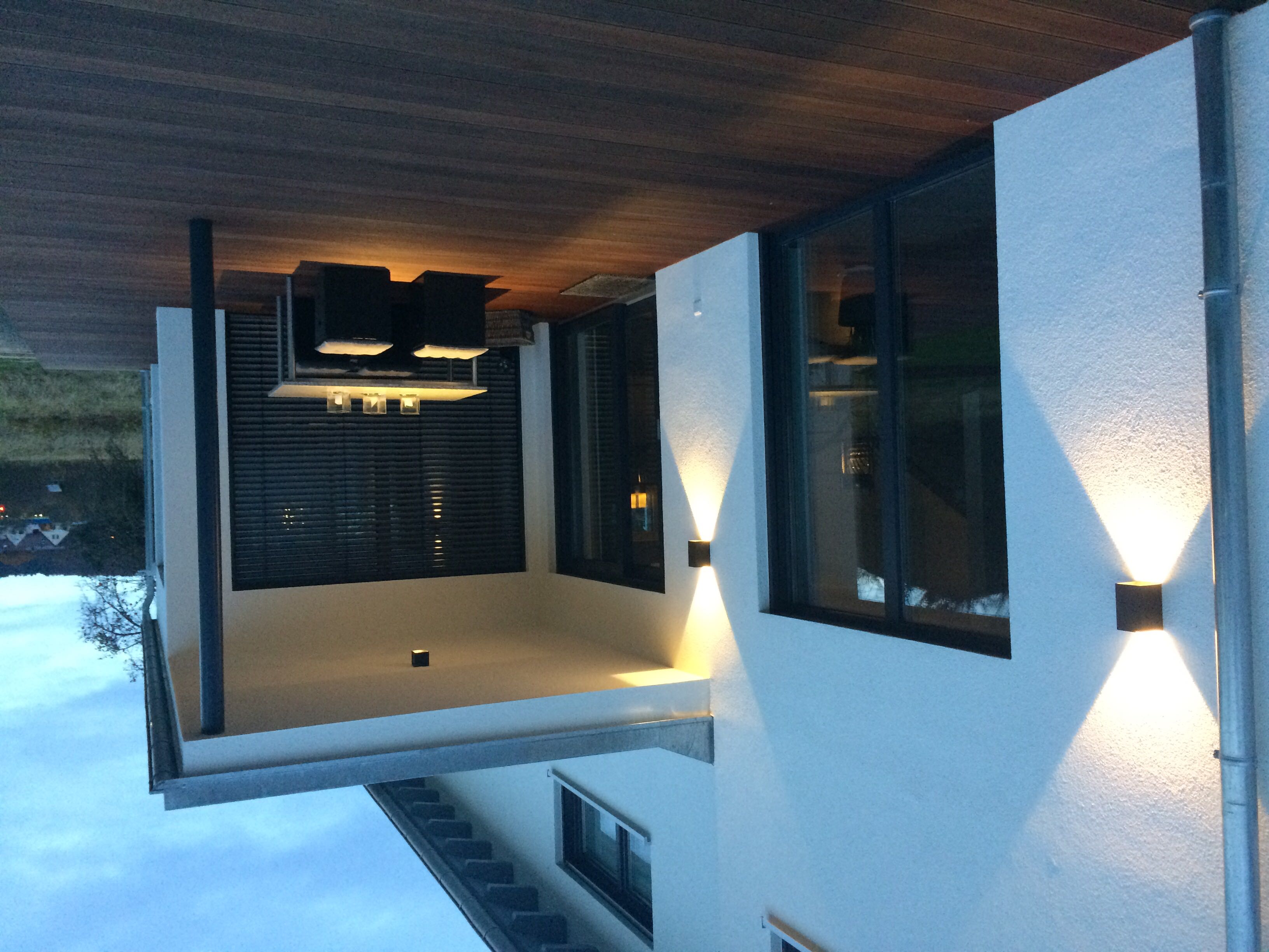 Moderne Terrasse mit warmen Wandleuchten und indirekter Beleuchtung